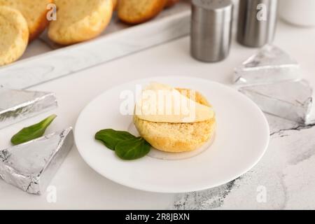 Assiette avec crouton et triangles de savoureux fromage fondu sur fond de marbre blanc Banque D'Images