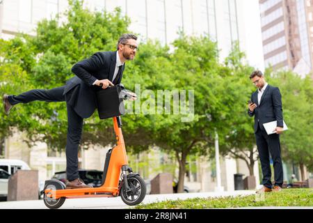 Le scooter électrique de l'homme d'affaires suscite la curiosité et la conversation. Homme d'affaires en scooter représente un style de vie moderne et urbain. Homme d'affaires Banque D'Images