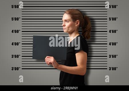 Coup de feu criminel. Femme arrêtée avec une carte vierge contre le tableau de hauteur Banque D'Images