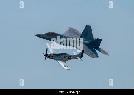 A ÉTATS-UNIS Le F-22 Raptor de la Force aérienne et un P-51 historique Mustang effectuent un vol patrimonial au-dessus de l'aéroport international de Rickenbacker, 18 juin 2023, dans le cadre du spectacle aérien de Columbus, qui est revenu après une absence de près de 20 ans. Cette année, plus de 20 avions militaires et civils, dont un KC-135 Stratotanker de la 121st Escadre de ravitaillement en vol, qui a servi de base d’opérations pour les avions militaires participant au spectacle. (É.-U. Photo de la Garde nationale aérienne par Tech. Sgt Wendy Kuhn) Banque D'Images