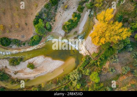 Vue aérienne zenithal de la rivière Algars qui traverse Arnes, le jour de l'automne (Terra Alta, Tarragone, Catalogne, Espagne) Banque D'Images