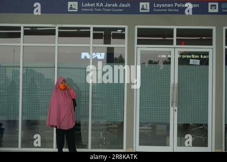 une femme portant un hijab attendant un train à la gare Banque D'Images