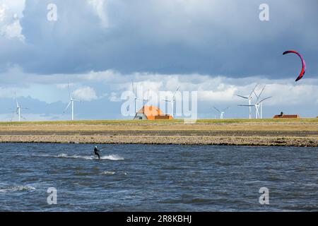 Un kite surfeur passe les vagues près du port de Dagebüll. Le district de Dagebüll Hafen (port de Dagebüll) est situé directement sur les rives de la mer des Wadden. Le port assure des liaisons régulières en ferry vers les charmantes îles de Foehr et d'Amrum. Banque D'Images