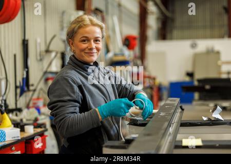 Jeune travailleuse industrielle travaillant en usine Banque D'Images