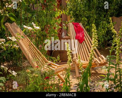 Chaises longues pliantes en bois dans un petit jardin à l'occasion d'un spectacle du jardin britannique. Banque D'Images