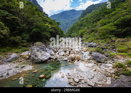 Photo idyllique d'un ruisseau traversant la vallée du parc national de Taroko. L'eau soyeuse se cascade sur de grandes pierres, créant une scène sereine. Au Shak Banque D'Images