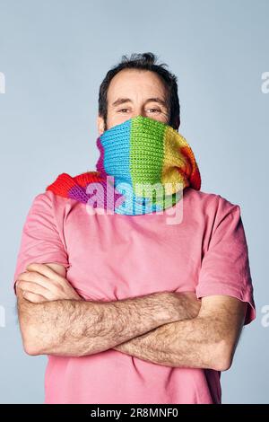 portrait vertical de l'homme fou couvrant son visage avec une écharpe arc-en-ciel. concept lgbt Banque D'Images