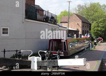 Lors d'une belle journée de fin de printemps à Worcester, un barge entre dans une écluse sur le canal de Birmingham et de Worcester. Banque D'Images