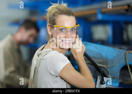 jeune femme travaillant dans un atelier de métal Banque D'Images