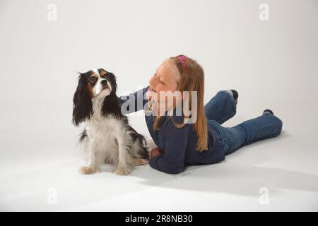 Fille avec cavalier King Charles, tricolore Banque D'Images