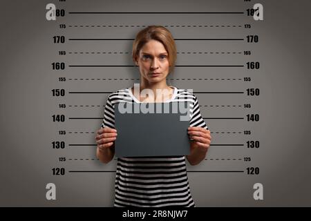 Coup de feu criminel. Femme arrêtée avec une carte vierge contre le tableau de hauteur Banque D'Images