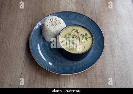 Le dishe asiatique culinaire Still Life. Curry Thaï au poulet, sauce au curry du chef avec lait de coco, basilic Banque D'Images