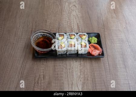Le dishe asiatique culinaire Still Life. Japanes Californie avec riz, thon, avocat, gingembre et sauces épicées Banque D'Images