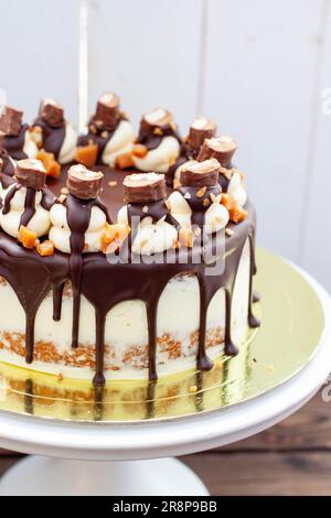 Gâteau inspiré de Twix avec chocolat fondu, biscuits, caramel salé et bar sucré Banque D'Images