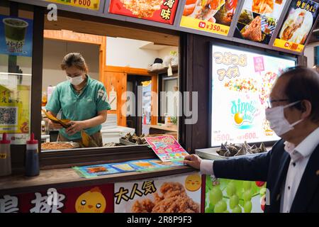 Yokohama, Japon. 22nd juin 2023. Un homme achète Zongzi, un boulonnage en forme de pyramide fait de riz gluant enveloppé de feuilles de bambou ou de roseau, à l'occasion du festival de bateau-dragon dans le quartier chinois de Yokohama, Japon, 22 juin 2023. Credit: Zhang Xiaoyu/Xinhua/Alay Live News Banque D'Images