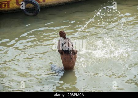 Un homme prie dans le Gange à Varanasi, Inde Banque D'Images