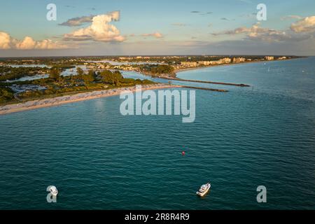 Vue aérienne de la mer près de Venise, Floride avec des yachts blancs au coucher du soleil flottant sur les vagues de la mer. North et South Jetty sur la plage de Nokomis. Bateau à moteur Banque D'Images