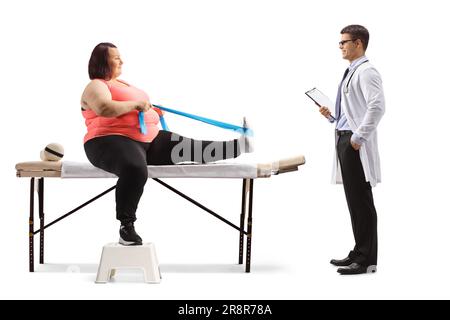 Femme en surpoids faisant de l'exercice avec une bande d'étirement et un médecin debout isolé sur fond blanc Banque D'Images