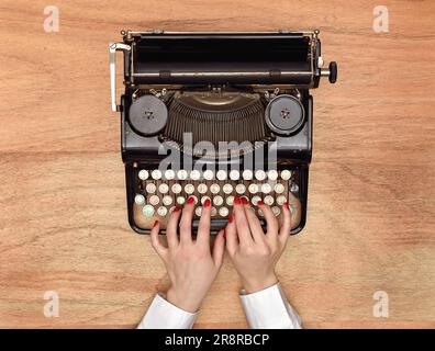Dactylographier les mains sur une machine à écrire Vintage. Vue de dessus Banque D'Images