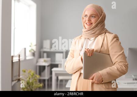 Femme musulmane programmeur avec ordinateur portable au bureau Banque D'Images