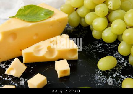 Embarquez avec de savoureux fromages suisses et des raisins sur la table Banque D'Images