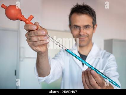 Pipeter avec le ballon Peleus dans le laboratoire de chimie. Également appelé propipet. Scientifique chimique en arrière-plan Banque D'Images