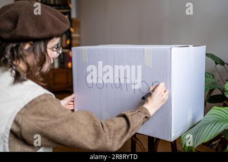 Une jeune femme organise des dons avant de déménager Banque D'Images