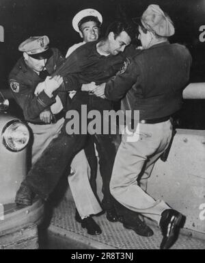 Tentative de suicide -- John Furtado, 32 ans, longshoreman à la base militaire d'Oakland, lutte avec les officiers sur la San Francisco à environ un mile à l'est de Yerba Buena Island et a grimpé sur une poutre en porte-à-faux Patrolman Luke Morley de la California Highway Patrol est monté après lui et a réussi au parler. Quand Furtado a atteint la route, d'autres agents ont tenté de mettre des menottes sur lui. Indigné, Furtado a couru jusqu'à la main courante au-dessus, mais a été attaqué avant qu'il puisse sauter. De gauche à droite : Patrolman Luke Morley ; Ed Utvick. Conducteur de voiture de service et Patrolman Mike Minihane. Furtado a dit aux officiers qu'il avait été… Banque D'Images