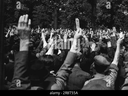 Les dockers restent à l'extérieur - le gouvernement entre les mains -- Une forêt de mains proclame l'intention des dockers de Londres de rester à l'extérieur, au mépris de l'intention du gouvernement de déclarer l'état d'urgence ce matin 11 juillet. Ils votaient lors d'une réunion de masse à Victoria Park Bethnal Green London, avec la participation d'environ 5 000 dockers. La proclamation de l'état d'urgence permet au Gouvernement de prendre des règlements d'urgence pour protéger les transports, la nourriture, l'eau et d'autres services essentiels. A la fin de la réunion des dockers, un membre du Comité de verrouillage les a avertis de rester en contact étroit avec le Comité, kee… Banque D'Images