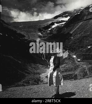 Pontresina -- la vie dans les Hautes Alpes de Suisse. Vue vers le dangereux Piz Palu. La dame en lunettes de soleil est un touriste anglais. Elle regarde l'environnement impressionnant depuis la hauteur de l'Alp Grum (7500 pieds). 22 janvier 1948. (Photo par Pictorial Press photo). Banque D'Images