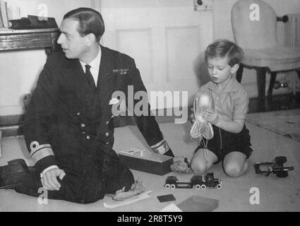 Le Prince Edward a un Bar GE Balloin parmi ses jouets de Noël cette année - le Prince Edward, ici vu avec son père, le duc de Kent, vu jouer avec un barrage baloon - un de ses cadeaux de Noël cette année. L'effet de la guerre sur les jouets ce Noël a été très perceptible et il est intéressant de voir que les jouets des enfants royaux montrent la même tendance. En plus du ballon de barrage de bar dans ses mains, le Prince Edward a aussi pour son amusement le "fusil de chasse et le camion de l'armée vu sur le sol près de lui. 21 décembre 1939. (Photo par Sport & General Press Agency, limites). Banque D'Images