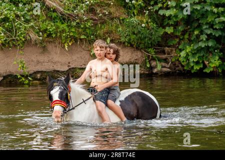 Deux garçons à cheval dans la rivière eden annuel appleby voyageurs gysey Foire traditionnelle du cheval juin 2023 cumbria. Banque D'Images