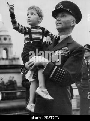 « Look Daddy » -- « look Daddy ! », déclare Richard, trois ans, alors que son père, le maréchal de la Royal Air Force Lord Tedder, le tient pour voir les avions qui tourmenaient sur le toit du ministère de l'Air ici, lors de la commémoration de la « bataille d'Angleterre » à Londres. Des millions de Londoniens ont regardé, et se sont souvenus, comme des centaines d'avions, dirigés par un seul combattant de l'Aviation royale, un ouragan, symbolique de « quelques », ont volé en formation à travers les cieux de Londres. Des avions de la Marine, l'Armée de l'Air des États-Unis, ainsi que des combattants et des bombardiers de la R.A.F., ont pris part au Fly-Past. 15 septembre 1949. Banque D'Images