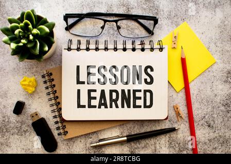 Carte vierge avec texte leçons apprises sur fond en bois.Concept d'entreprise Banque D'Images