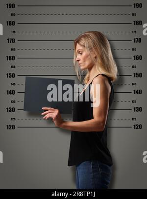 Coup de feu criminel. Femme arrêtée avec une carte vierge contre le tableau de hauteur Banque D'Images