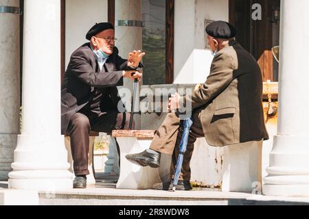 Deux hommes âgés ont une conversation dans un parc à Pristina, au Kosovo Banque D'Images