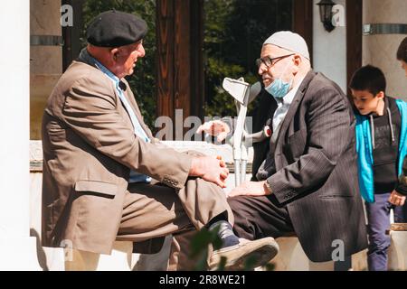 Deux hommes âgés ont une conversation dans un parc à Pristina, au Kosovo Banque D'Images