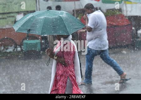 Les navetteurs se rendent dans une rue où l'eau est engorgé lors de fortes pluies à Agartala. Tripura, Inde. Banque D'Images