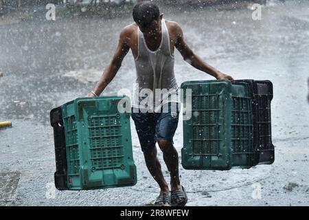 Les navetteurs se rendent dans une rue où l'eau est engorgé lors de fortes pluies à Agartala. Tripura, Inde. Banque D'Images