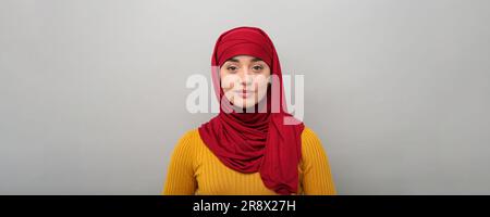 Portrait de la femme musulmane dans le hijab sur fond gris clair. Bannière Banque D'Images
