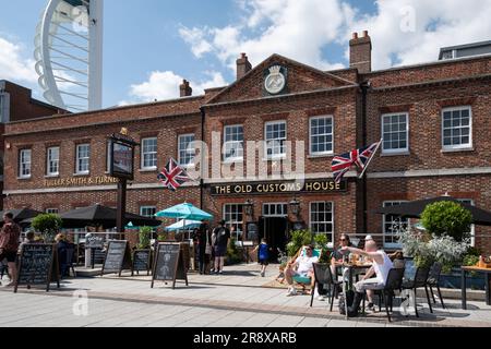 Gunwharf Quays à Portsmouth un jour ensoleillé d'été en juin avec des gens assis à l'extérieur du pub Old Customs House, Hampshire, Angleterre, Royaume-Uni Banque D'Images