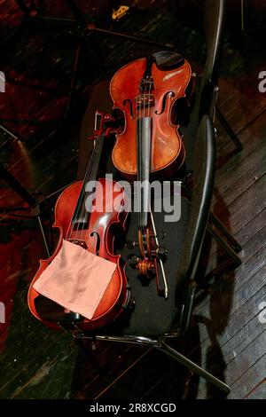 Image deux violons d'un orchestre symphonique reposent sur des chaises pendant l'entracte Banque D'Images