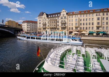 Berlin, Allemagne - 18 avril 2023 : vue sur un bateau d'excursion touristique sur la rivière Spree et divers bâtiments résidentiels en arrière-plan à Berlin Banque D'Images