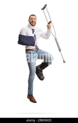 Homme heureux se rétablissant d'une blessure et sautant avec une béquille isolée sur fond blanc Banque D'Images
