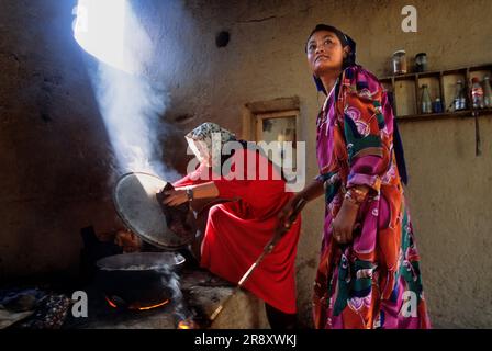 Les femmes cuisinent à feu ouvert dans la cuisine d'une maison traditionnelle du nord de l'Afghanistan, à la périphérie de Mazar-i Sharif, en Afghanistan Banque D'Images