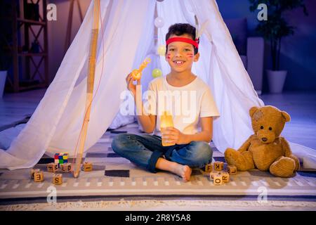 Photo d'un petit garçon de frère mignon assis dans la maison indienne d'origine soufflez des bulles de savon dans la salle de jeux de pépinière du soir Banque D'Images