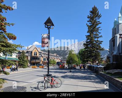 Banff ville Alberta Canada entourée de montagnes. Les bices se penchent contre le montant de la lampe Banque D'Images