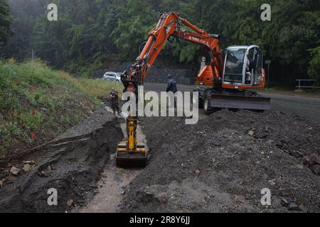 Thale, Allemagne. 23rd juin 2023. Les employés de la cour du bâtiment déblayer une tranchée à Thale. Le lendemain de la tempête, le travail de nettoyage est en plein essor. Dans le district de Harz en particulier, plusieurs villes comme Thale ont été directement touchées par la tempête. À Thale, des masses d'eau ont lavé des tonnes de débris sur une route et dans un fossé. La route était fermée jusqu'à midi. Credit: Matthias Bein/dpa/Alay Live News Banque D'Images