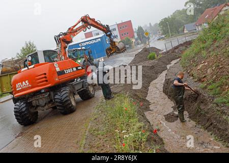 Thale, Allemagne. 23rd juin 2023. Les employés de la cour du bâtiment déblayer une tranchée à Thale. Le lendemain de la tempête, le travail de nettoyage est en plein essor. Dans le district de Harz en particulier, plusieurs villes comme Thale ont été directement touchées par la tempête. À Thale, des masses d'eau ont lavé des tonnes de débris sur une route et dans un fossé. La route était fermée jusqu'à midi. Credit: Matthias Bein/dpa/Alay Live News Banque D'Images