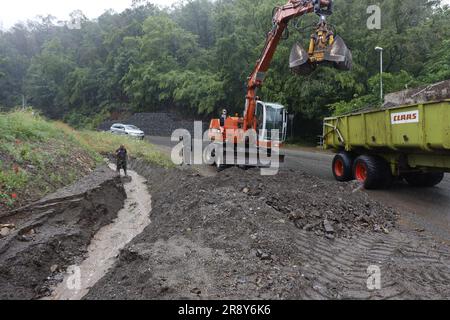 Thale, Allemagne. 23rd juin 2023. Les employés de la cour du bâtiment déblayer une tranchée à Thale. Le lendemain de la tempête, le travail de nettoyage est en plein essor. Dans le district de Harz en particulier, plusieurs villes comme Thale ont été directement touchées par la tempête. À Thale, des masses d'eau ont lavé des tonnes de débris sur une route et dans un fossé. La route était fermée jusqu'à midi. Credit: Matthias Bein/dpa/Alay Live News Banque D'Images